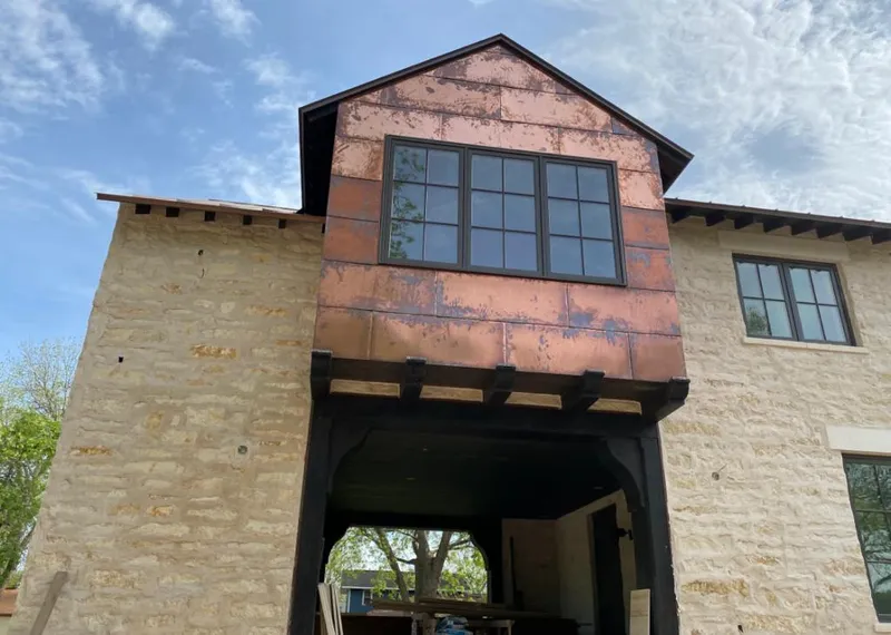 Copper metal panel facade on a stone building for Roof Repair in Decorah